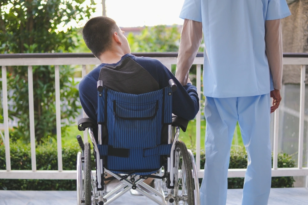 Disabled man in wheelchair with nurse