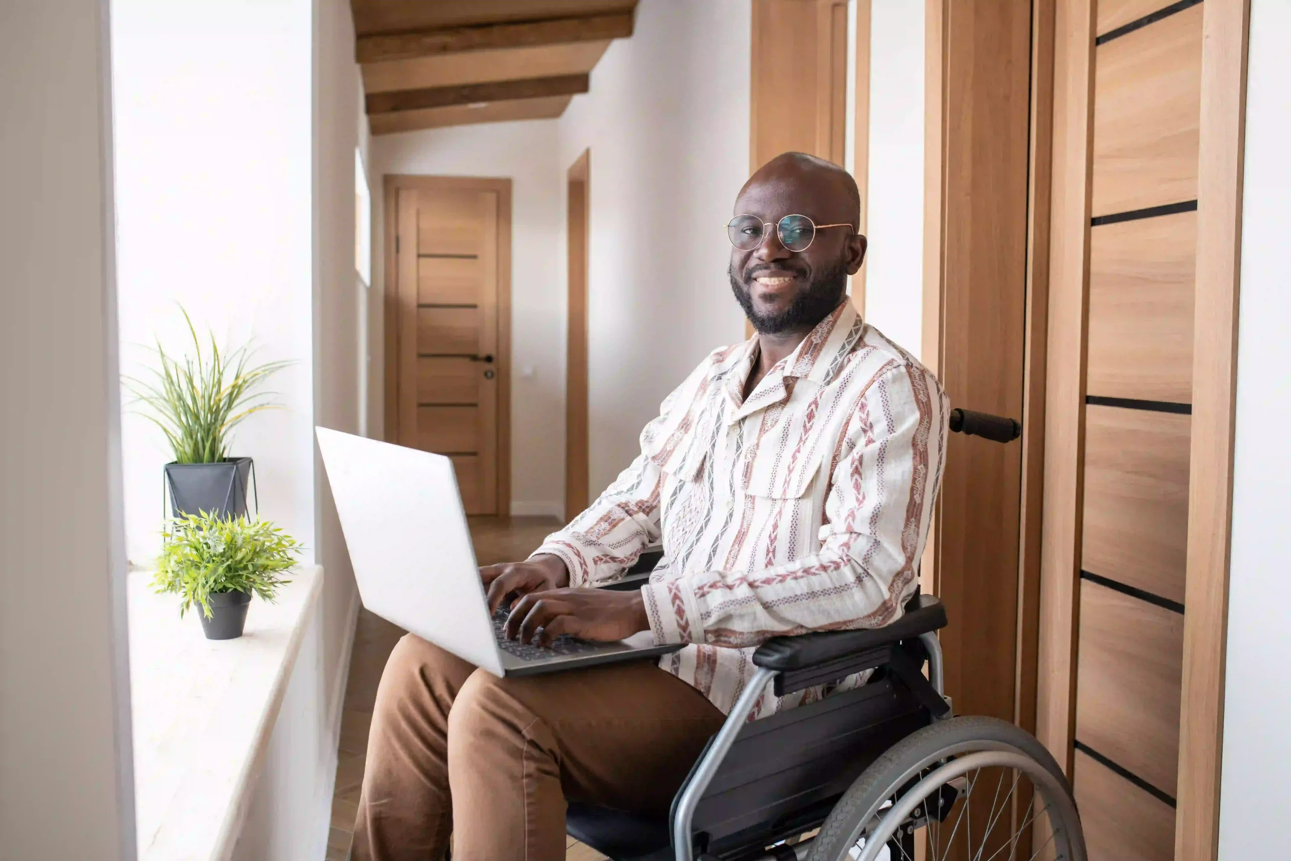 Disabled man in wheelchair using laptop